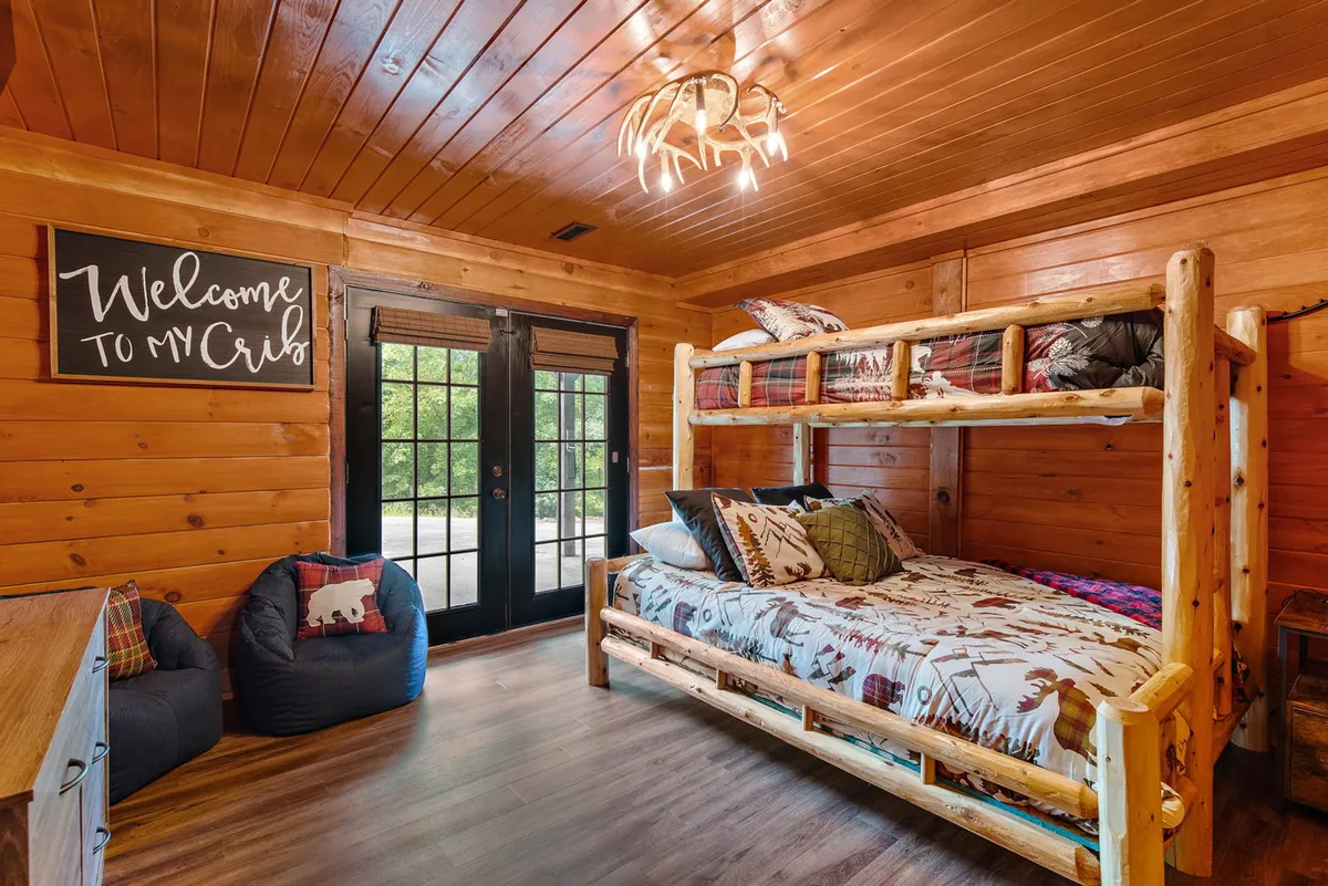 A playful bunk room with a full-over-queen bunk bed, bean bag chairs, and a welcome sign. The room is colorful and inviting, perfect for children, teens, or friends looking to create lasting memories.